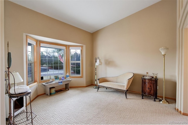 living area featuring vaulted ceiling, carpet, and baseboards