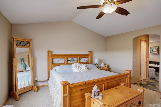 bedroom featuring arched walkways, vaulted ceiling, a ceiling fan, and light colored carpet