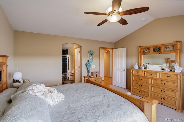 bedroom featuring light carpet, arched walkways, vaulted ceiling, and a ceiling fan