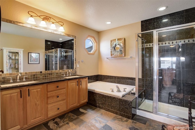 bathroom featuring a garden tub, a sink, a shower stall, and double vanity