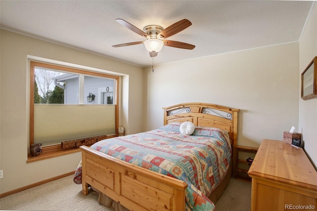 bedroom with a ceiling fan, light carpet, and baseboards