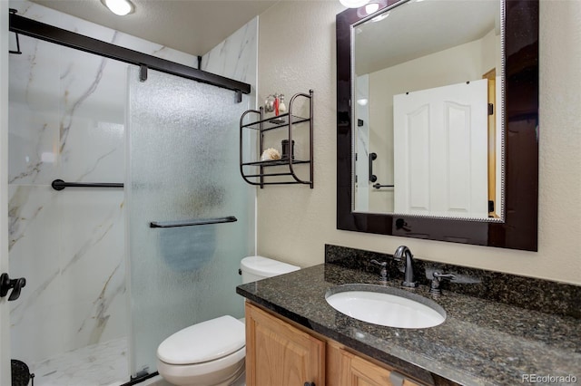 full bathroom featuring a textured wall, toilet, vanity, and a marble finish shower