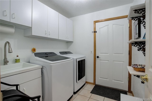 washroom with light tile patterned floors, washing machine and clothes dryer, and cabinet space