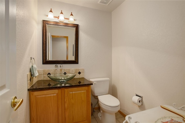 bathroom with toilet, vanity, visible vents, and tile patterned floors