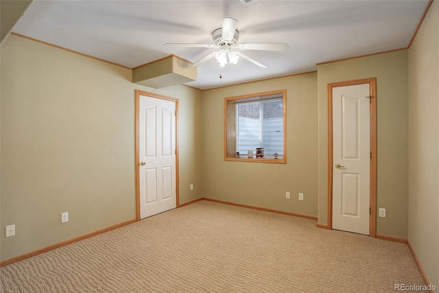 interior space featuring light carpet, ceiling fan, baseboards, and crown molding