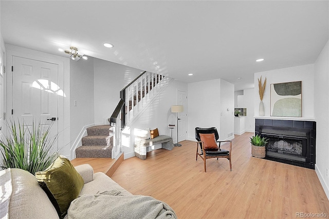 living room featuring a tile fireplace and hardwood / wood-style flooring