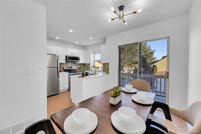 dining room featuring a notable chandelier and light hardwood / wood-style flooring