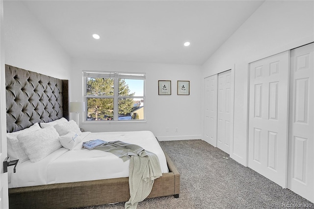 bedroom featuring multiple closets, carpet floors, and lofted ceiling