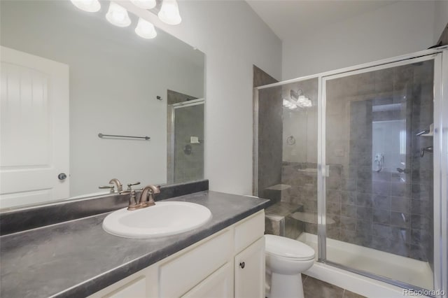 bathroom with tile patterned flooring, toilet, vanity, and walk in shower