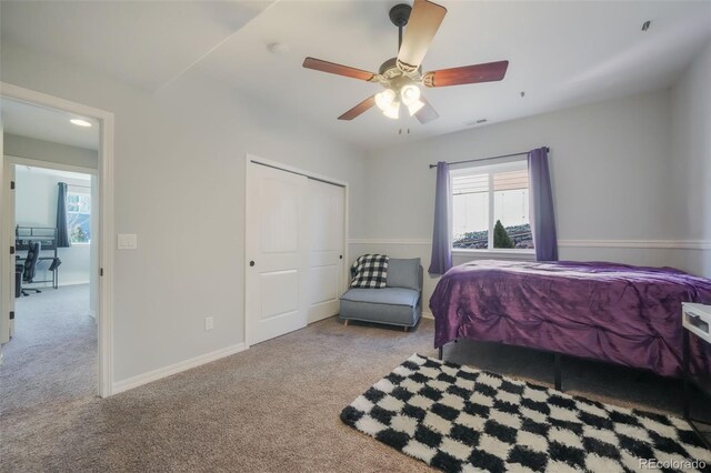 bedroom with ceiling fan, light colored carpet, and a closet