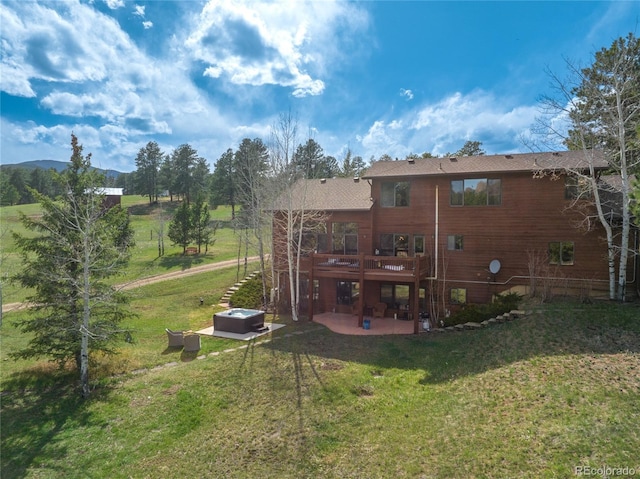 back of property featuring a lawn, a patio area, and a deck
