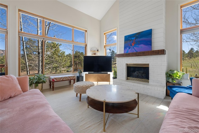 living area with a fireplace and high vaulted ceiling