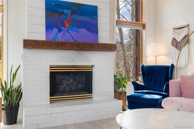 living room with wood finished floors and a brick fireplace