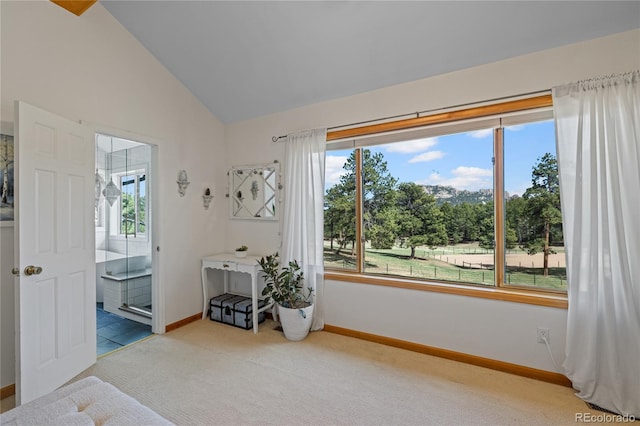 carpeted bedroom featuring ensuite bath, baseboards, lofted ceiling, and multiple windows
