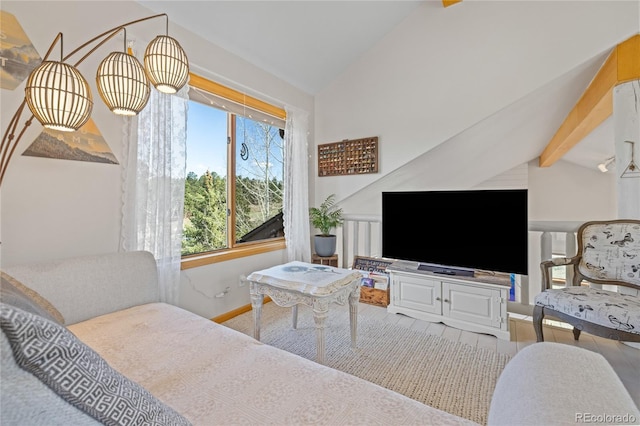 bedroom with wood finished floors, vaulted ceiling with beams, and baseboards