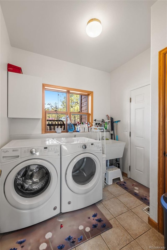 laundry room featuring independent washer and dryer, light tile patterned floors, and laundry area