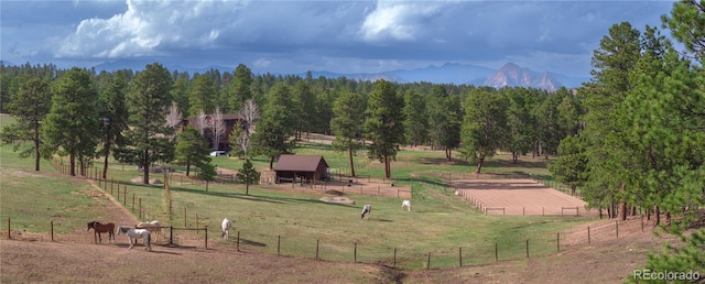 surrounding community with a rural view, an outbuilding, and fence