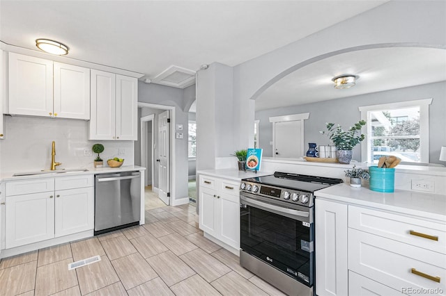 kitchen featuring stainless steel appliances, sink, and white cabinets