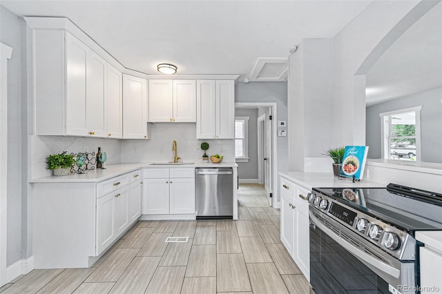 kitchen featuring appliances with stainless steel finishes, sink, decorative backsplash, and white cabinets