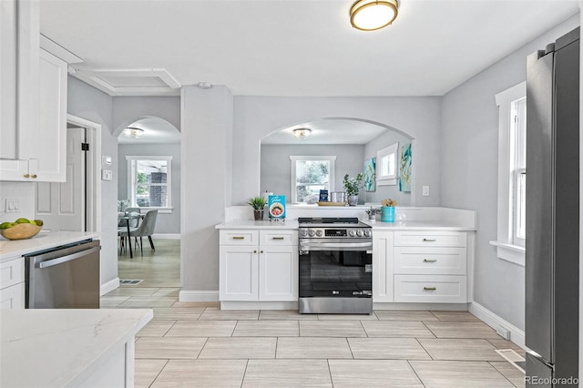 kitchen featuring light stone counters, white cabinets, and appliances with stainless steel finishes