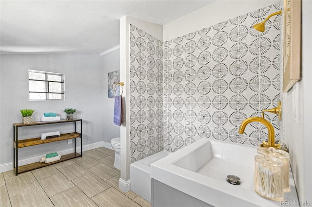 bathroom featuring toilet, sink, and a tub to relax in