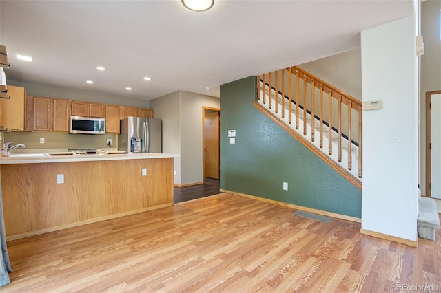 8791 Starwood Ln, Parker, CO 80134 - kitchen featuring stainless steel appliances, light wood-type flooring, recessed lighting, a peninsula, and light countertops