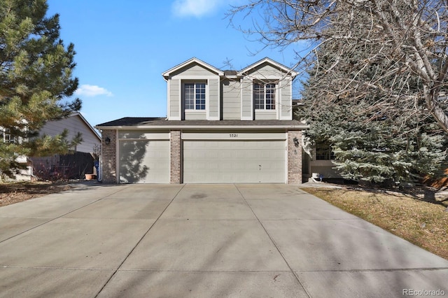 traditional home featuring a garage, driveway, and brick siding