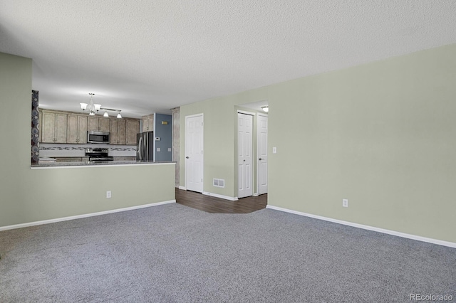 unfurnished living room featuring visible vents, dark carpet, a textured ceiling, and a notable chandelier