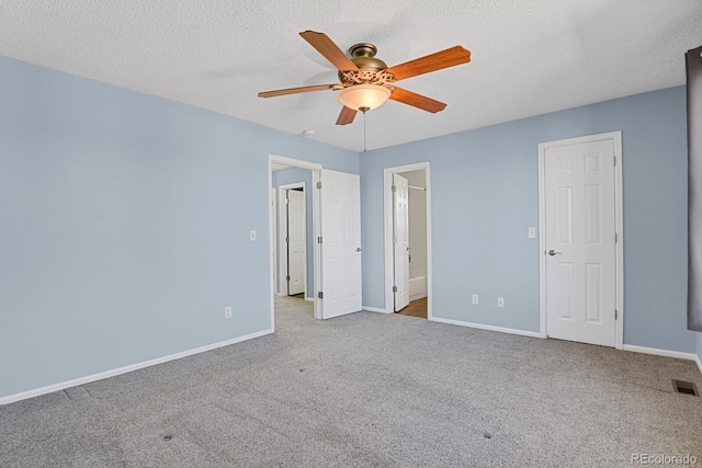 interior space with a textured ceiling, carpet, visible vents, and baseboards