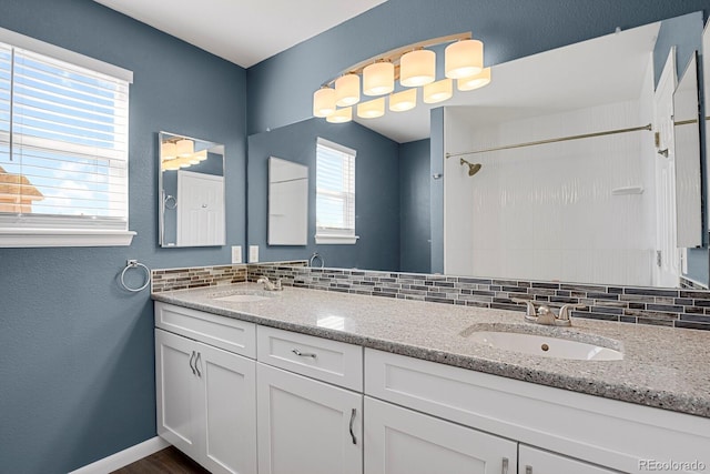 bathroom with a sink, decorative backsplash, and double vanity