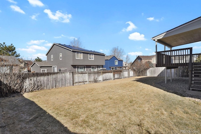 view of yard featuring a fenced backyard, a residential view, and stairway