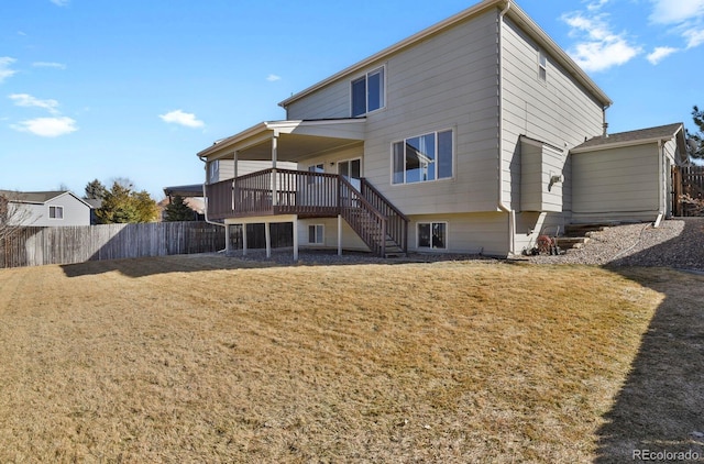 back of property with a deck, a yard, stairway, and fence