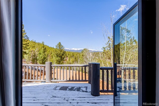 wooden deck with a view of trees and a mountain view