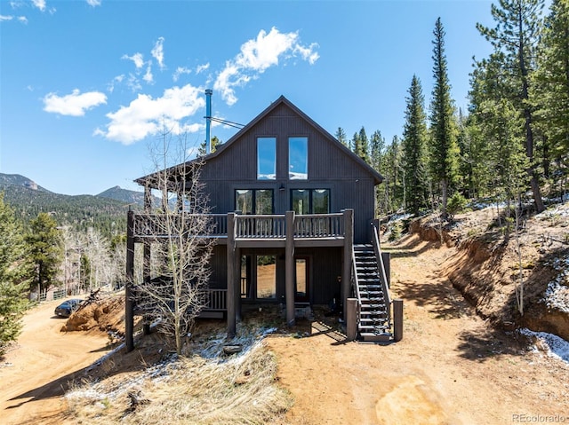 rear view of house featuring stairs and a deck with mountain view