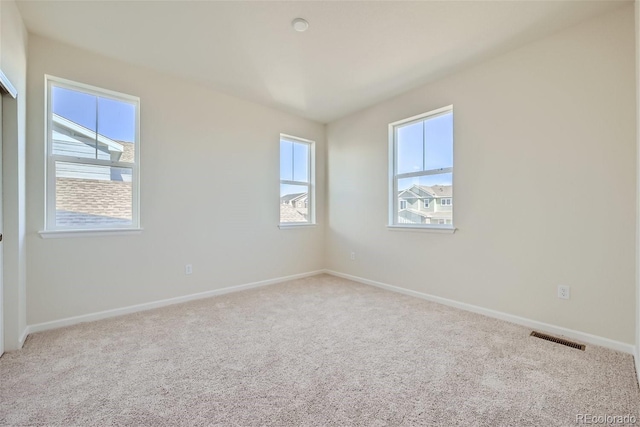 carpeted empty room featuring plenty of natural light