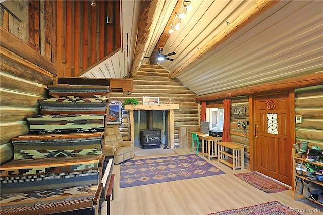 420 Quarzt Ln, Pitkin, CO 81241 - sitting room with rustic walls, a wood stove, a ceiling fan, and wood finished floors