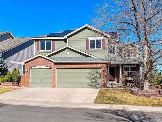 traditional home with a garage, solar panels, concrete driveway, and brick siding