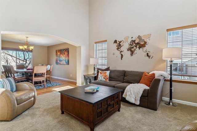 living room with baseboards, a chandelier, and a wealth of natural light