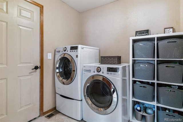 washroom with laundry area, visible vents, washer and clothes dryer, and light tile patterned flooring