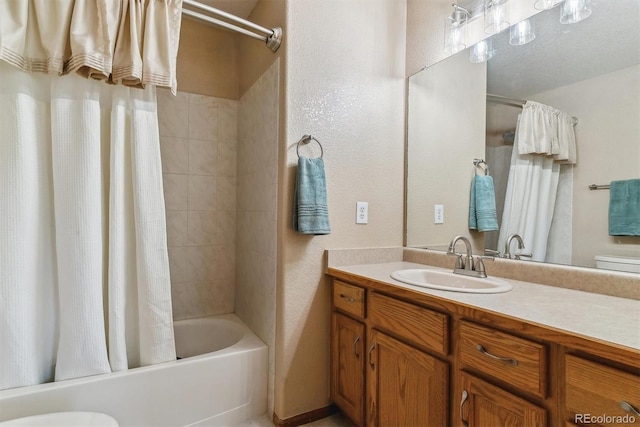 full bathroom with shower / tub combo, a textured wall, vanity, and toilet