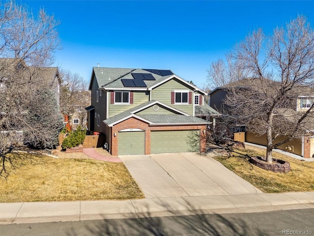 view of front of property featuring brick siding, concrete driveway, a front yard, roof mounted solar panels, and a garage