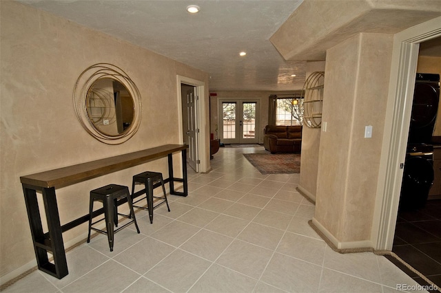 hall featuring light tile patterned floors and french doors