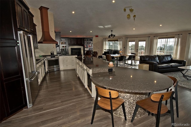 kitchen with dark brown cabinets, dark hardwood / wood-style floors, and appliances with stainless steel finishes