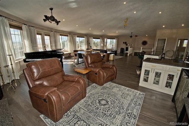 living room featuring dark wood-type flooring and ceiling fan