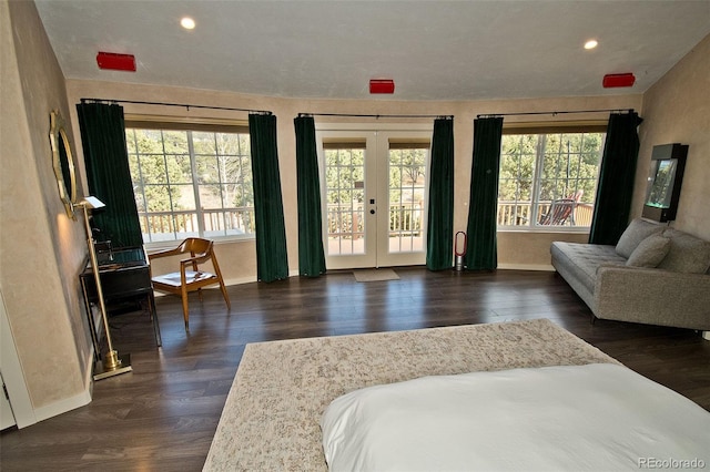 bedroom with dark wood-type flooring, access to outside, multiple windows, and french doors