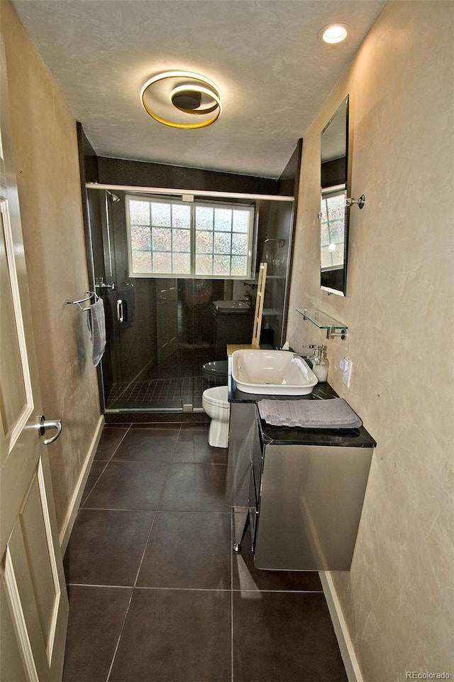 bathroom with walk in shower, tile patterned flooring, vanity, and toilet