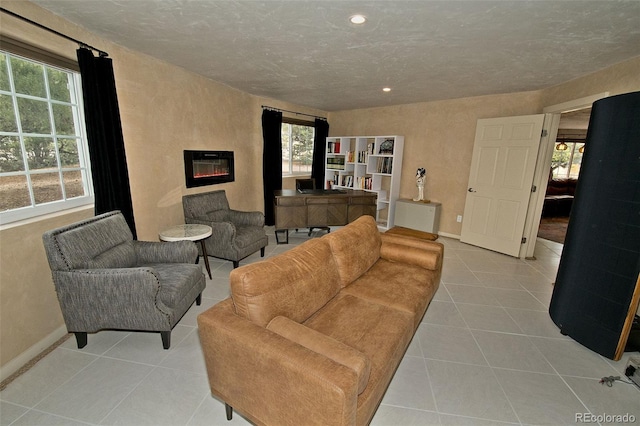 living room featuring a textured ceiling and light tile patterned floors