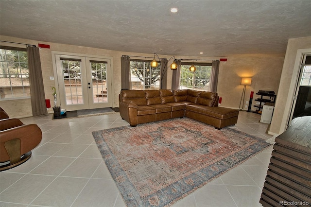 tiled living room featuring a wealth of natural light, french doors, and a textured ceiling