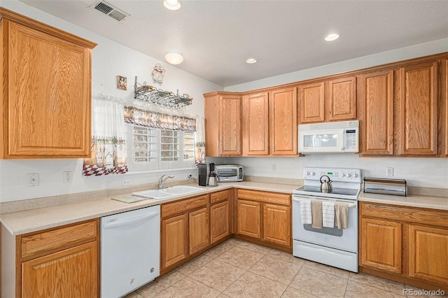 kitchen featuring light tile patterned flooring, white appliances, and sink