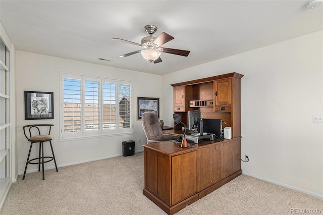 carpeted office space with ceiling fan